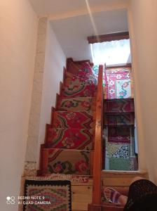 吉诺卡斯特Guest House Salaria的一座房子里的楼梯,铺着色彩缤纷的地毯
