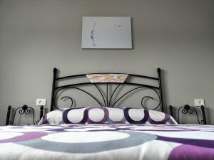 科尔库维翁O Vendaval的一间卧室配有一张黑色床,提供紫色和白色枕头