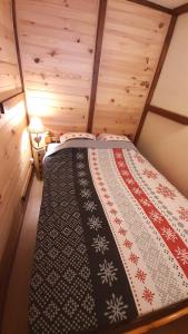梅塔比耶Au Doubs Refuge的木制客房内的一间卧室,配有一张床