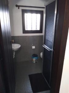 蒙特韦尔迪Pousada Vênus的一间带水槽和卫生间的浴室以及窗户。