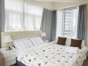 达沃市Inspiria的卧室设有白色的床和大窗户