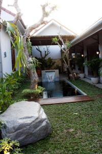 日惹格兰德玛尔托酒店的房屋前带池塘的花园