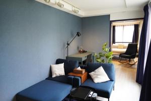 札幌Glass Shiseikan的蓝色的客厅配有沙发和桌子