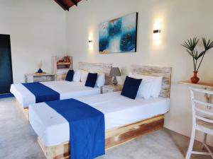 尼拉瓦利Anukama Resort的蓝色和白色的客房内的两张床