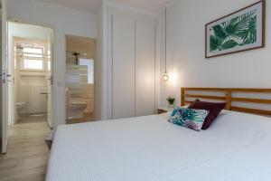 维拉·雷阿尔·德·桑托亚瓜迪亚纳河公寓的一间带白色大床的卧室和一间浴室