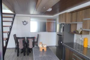 普诺Departamento 3 niveles- Vista Panoramica 360 grados a toda la ciudad y Lago Titicaca的厨房配有桌椅和冰箱。