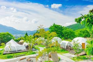 由布市The Village Yufuin Onsen Glamping的享有带帐篷和树木的度假村美景