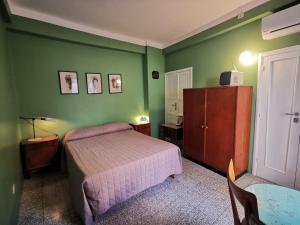 阿尔塔穆拉Casa Farella B&B in mini Apartments Altamura x Matera的一间卧室设有绿色的墙壁、一张床和一张桌子