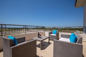珊瑚湾Sea Point Villas的阳台配有椅子和一张桌子及一瓶葡萄酒
