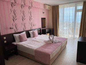 普里莫尔斯科Hotel Ancora Beach的一间卧室配有一张带粉红色墙壁的大床