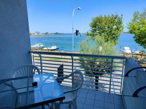 格拉多卡普里酒店的阳台配有桌椅,享有水景。