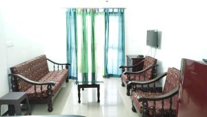瓦尔恰Seacoast Retreat- Lovely 2 BHK apartment with pool的一间设有一排椅子和窗帘的等候室