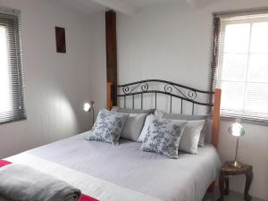 斯托姆勒菲Storms River Tin House的一间卧室配有带白色床单和枕头的床。