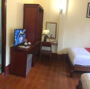 琅勃拉邦苏提考恩1号酒店的酒店客房配有一张床和一张书桌及一台电视