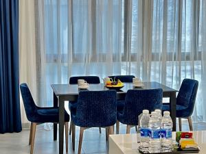 迪拜ABAR HOTEL APARTMENTS DIP-1的用餐室配有桌椅和水瓶