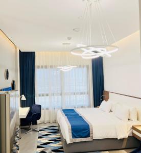迪拜ABAR HOTEL APARTMENTS DIP-1的一间卧室配有一张床、一张书桌和一个吊灯。