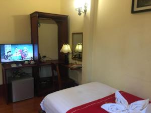 琅勃拉邦苏提考恩1号酒店的酒店客房,配有床和电视