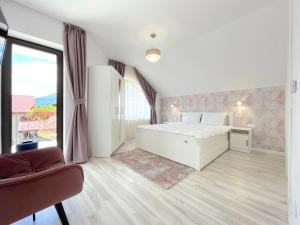 布拉索夫Vila Rolizo的卧室设有白色的床和大窗户