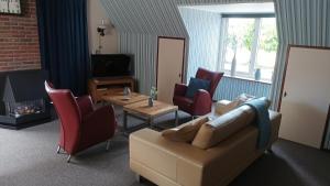 罗登Vakantie appartement de Havezate的客厅配有沙发、椅子和壁炉