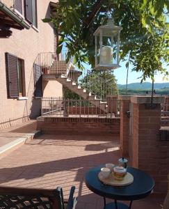 蒙塔尔奇诺Appartamento Il Glicine的楼梯旁的一张带杯的蓝色桌子