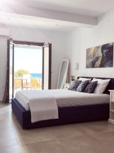 安倍拉斯All Blue Suites的一间卧室设有一张大床和一个大窗户