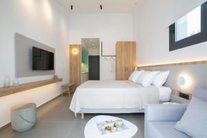 尼基亚娜Elianthi Luxury Apartments的一间卧室配有一张床、一张沙发和一台电视。