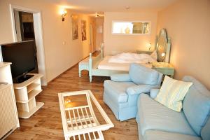Warnitz奥贝鲁克尔塞全景酒店的客厅配有蓝色的沙发和床。