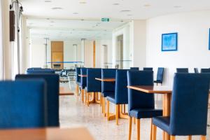 波瓦桑度马尔酒店 的一间配备有蓝色椅子和桌子的用餐室