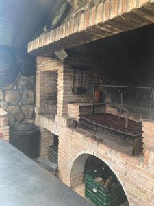 BustarviejoCasa Rural LOS TINES的石墙的室外砖炉
