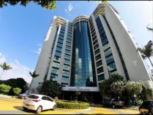 马瑙斯Tropical Executive Vista pra Praia的停在大楼前停车场的白色汽车