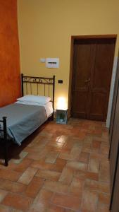 Torre Orsina诺尼旅馆的卧室配有1张床,铺有瓷砖地板。