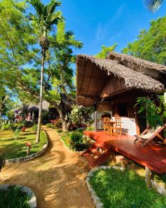 AmpangorinanaTamarin Lodge的配有木桌和长凳的度假酒店