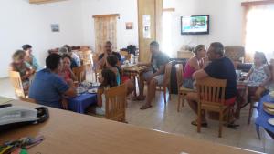 Agía MarínaAerikohotel - Apartments的一群坐在餐厅桌子上的人