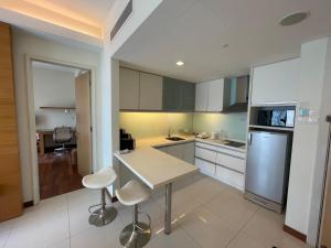 吉隆坡Cormar Suites, Jalan Perak的厨房配有白色橱柜和桌椅