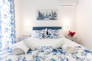科孚镇oliva e mare luxury suite的卧室配有蓝色和白色的床,墙上挂着帆板