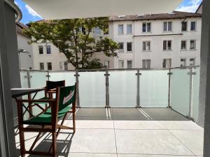 布伦瑞克TomsFlat BRAUNSCHWEIG - 3 ROOMS, KITCHEN, WORKSPACE, HIGHSPEED WIFI, WASHER & DRYER, BALCONY的享有大楼景致的阳台上的椅子