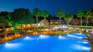 费特希耶Lykia Botanika Beach Fun & Club - All Inclusive的一座带椅子和棕榈树的大型游泳池