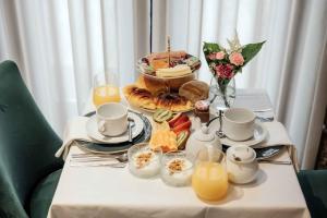 吉马良斯Trovador Guest House的一张桌子,上面放着一盘早餐食品和橙汁