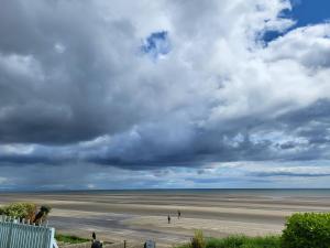 贝提斯顿Bovinda Cottage - By the Beach, Bettystown的海滩上有人在沙滩上散步