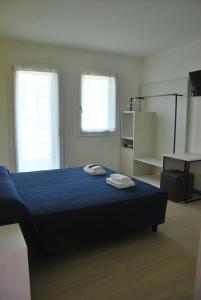 拉齐塞B&B da Rosy的一间卧室配有蓝色的床和2条毛巾