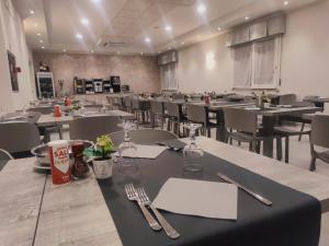 里米尼Hotel Bergamo的用餐室配有桌椅和餐具