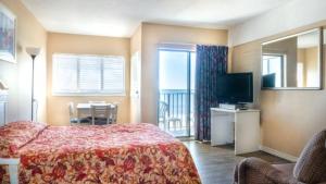 默特尔比奇Wave Rider Resort的酒店客房设有床、电视和桌子。