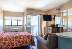 默特尔比奇Wave Rider Resort的一间卧室配有一张床、一张沙发和一台电视