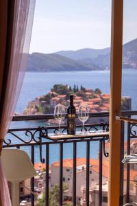 斯韦蒂·斯特凡Vertmont Villa的阳台上提供一瓶葡萄酒和两杯酒杯