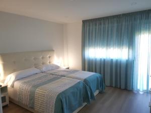莫阿尼亚Apartamento Gran Terraza的一间卧室设有一张大床和一个窗户。