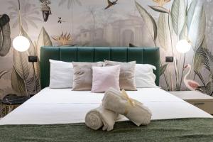 阿格里真托Ammare rooms的一间卧室配有一张白色大床和绿色床头板