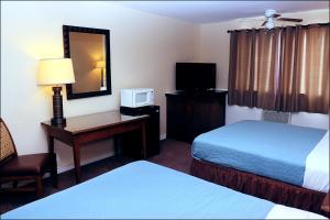 KemmererAntler Motel的酒店客房设有两张床和一张书桌及电视