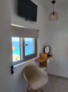 卡尔帕索斯Agnantema luxury suites的椅子坐在带窗户的房间