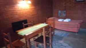皮拉米德斯港el refugio piramides的小房间设有桌子和床