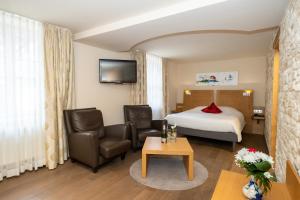 维桑堡维桑布尔拉卡尼酒店的酒店客房配有一张床、两把椅子和一张桌子